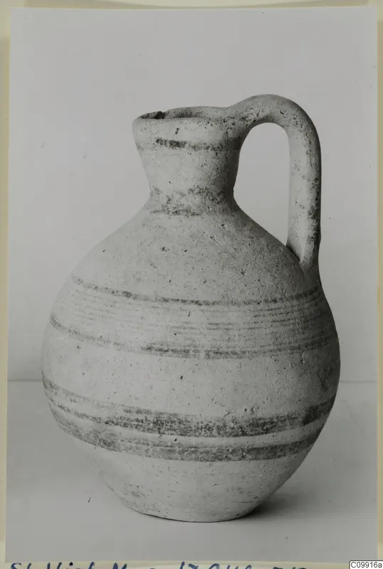 White Painted V jug with a single loop handle and dark painted bands, photographed against a plain background