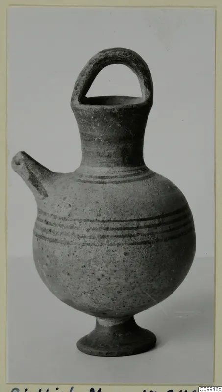 White Painted III jug with a strap handle, side spout and ring foot