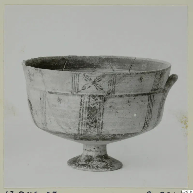 Footed bowl with a loop handle, painted horizontal bands, vertical panels and a cross-like motif