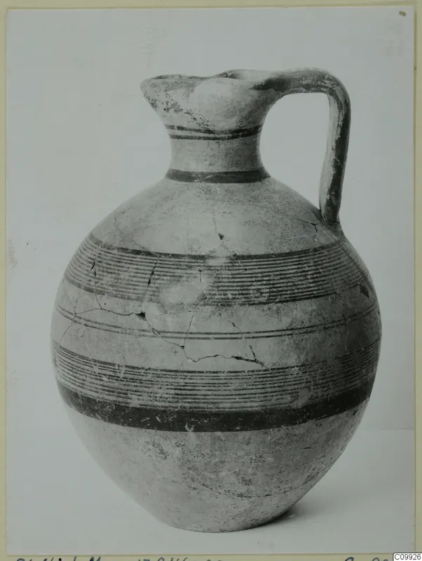 Single-handled jug with a pinched mouth and horizontal bands of dark paint on its body and neck