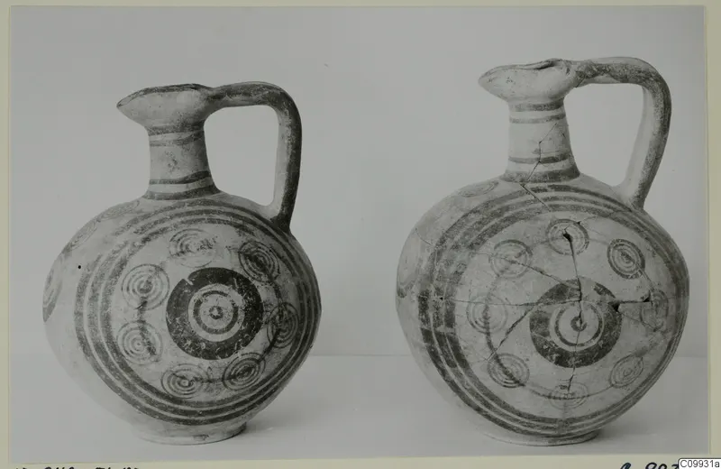 Two pottery jugs side by side, decorated with dark bands and concentric circle motifs