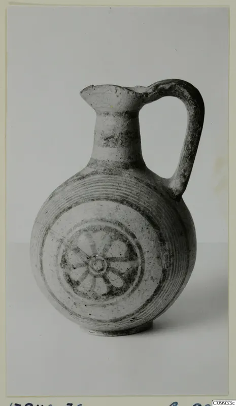 Round-bodied jug with a loop handle, painted with concentric bands and a central spoked wheel motif