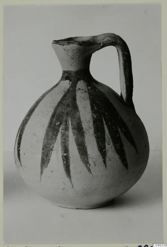 Round-bodied jug with a tall flaring neck and strap handle, decorated with dark vertical leaf-like bands.