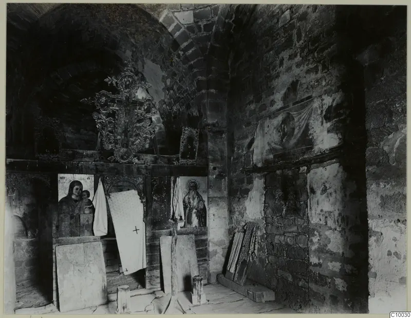 Interior of the Fokas chapel at Dali monastery, with painted icons on a wooden screen and a carved cross above