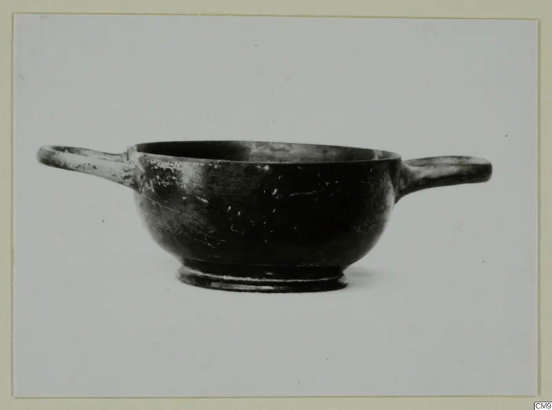 Black-glazed two-handled bowl with a low foot, seen from the side