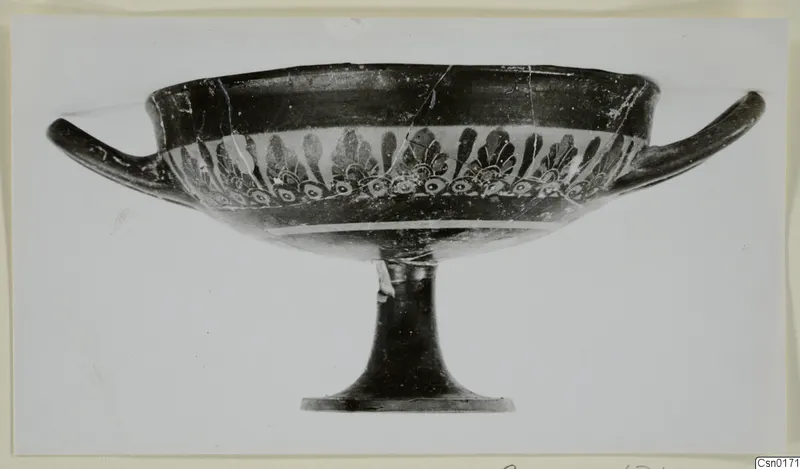 Stemmed bowl with two horizontal handles and a band of dark palmette motifs, seen from the side.