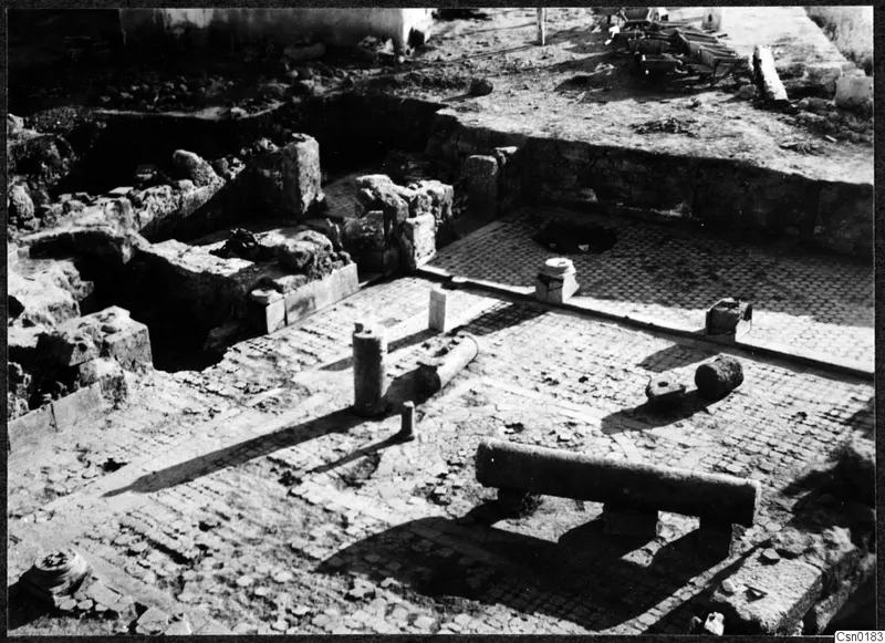 Excavated stone walls and a small-stone paved floor with column drums at Salamis, Famagusta