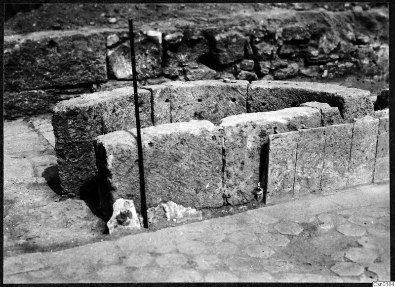 Curved stone wall of large dressed blocks at Salamis, with a paved floor in front of it.
