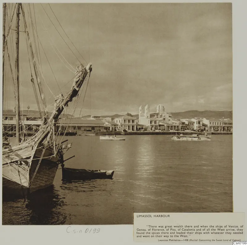 Limassol harbour with a moored sailing ship in the foreground, small boats on the water and a church with twin towers along the waterfront.