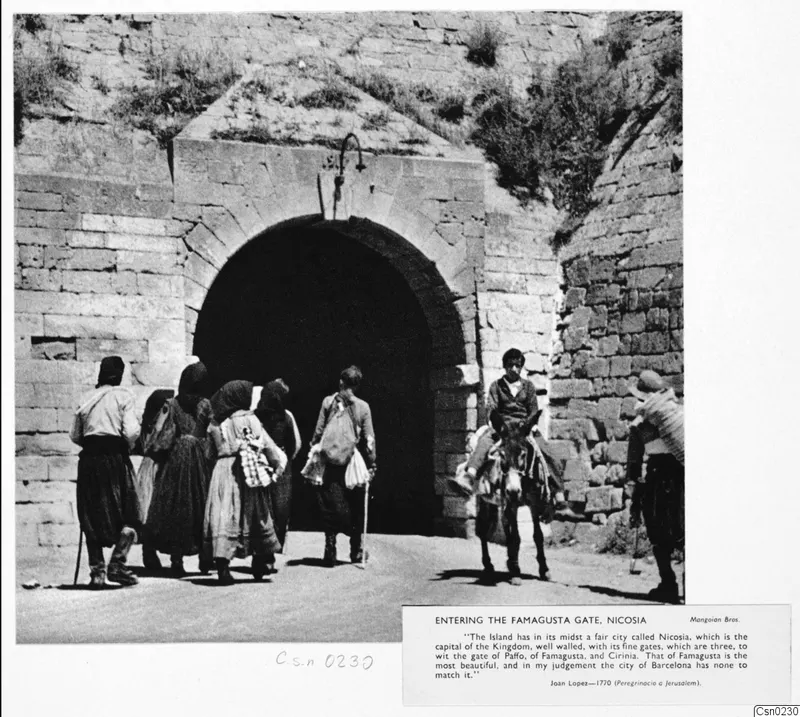 Several people and a donkey rider walk toward the arched Famagusta Gate in Nicosia