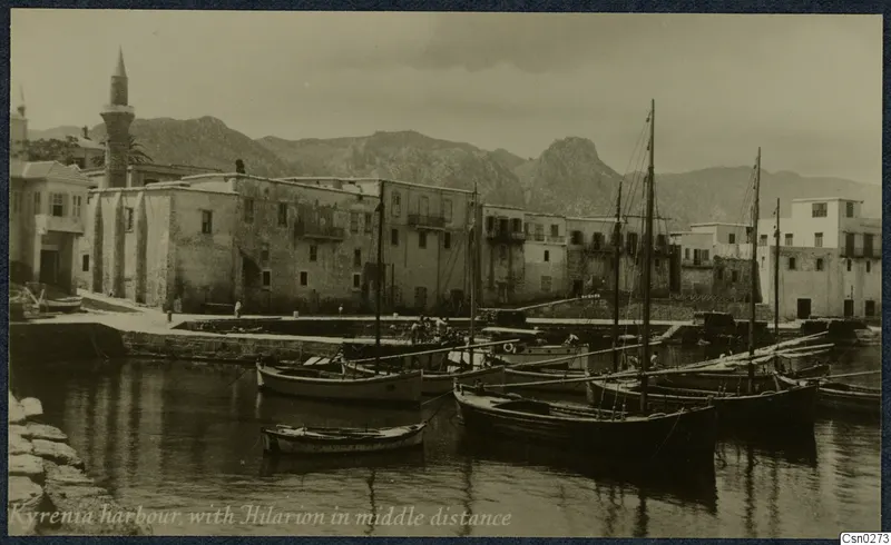 Kyrenia harbour with moored boats, waterfront buildings and rocky mountains behind