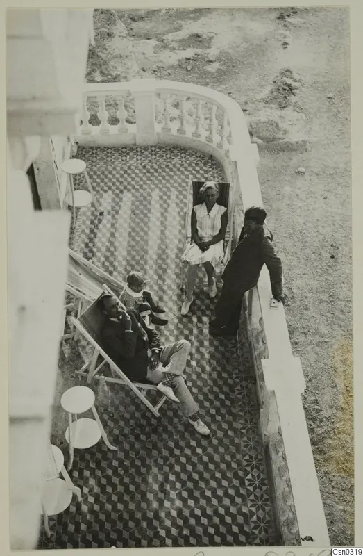 Hotel terrace in Kyrenia with members of the Swedish excavation relaxing on deckchairs above a tiled floor.