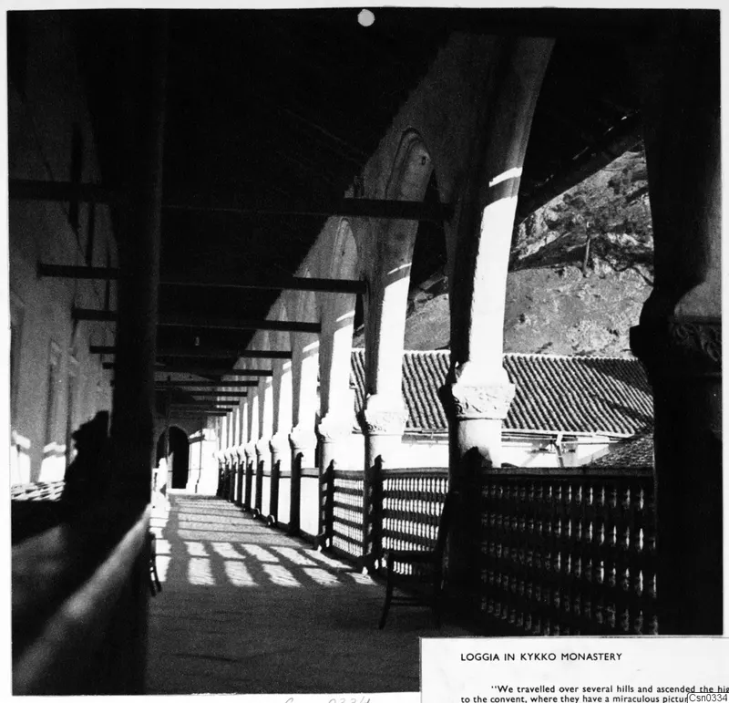 Loggia with columns and arches at Kykko Monastery, with light striping the paved walkway.