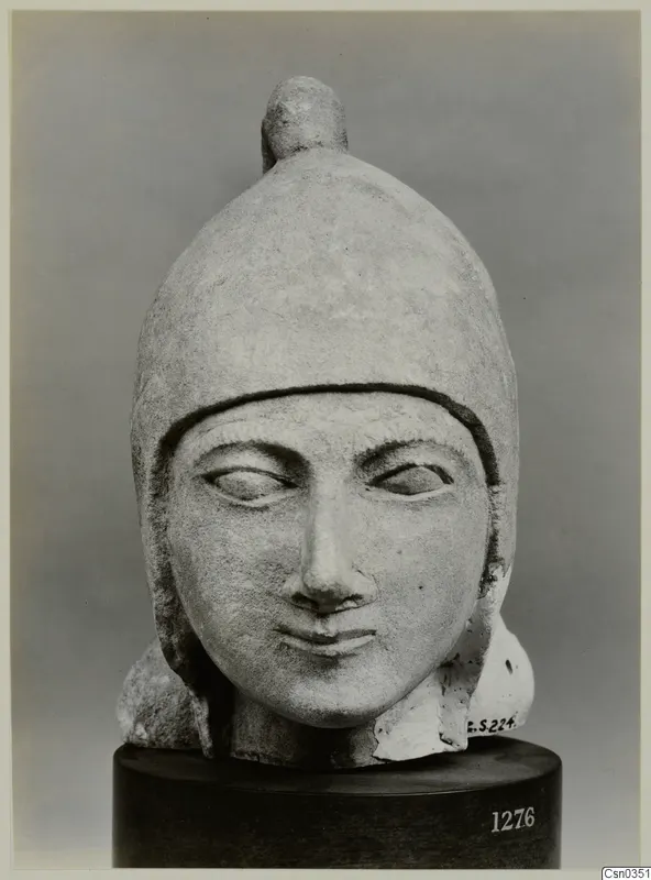 Limestone head with a helmet-like cap and knob on top, from the Cesn. Coll.
