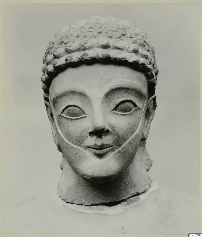 Limestone head and upper bust with curled hair and large almond-shaped eyes