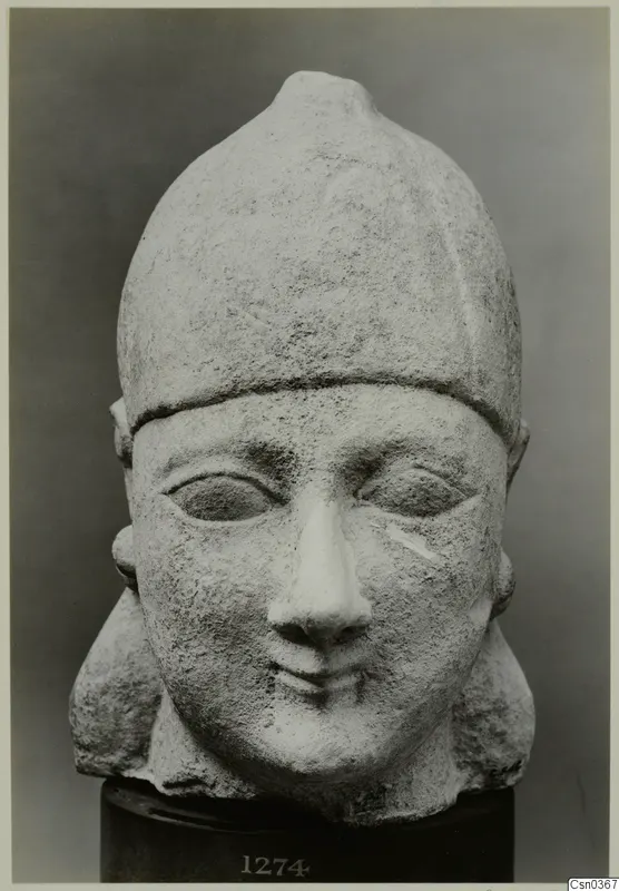 Limestone Neo-Cypriote head with a tall rounded cap, shown on a dark cylindrical stand