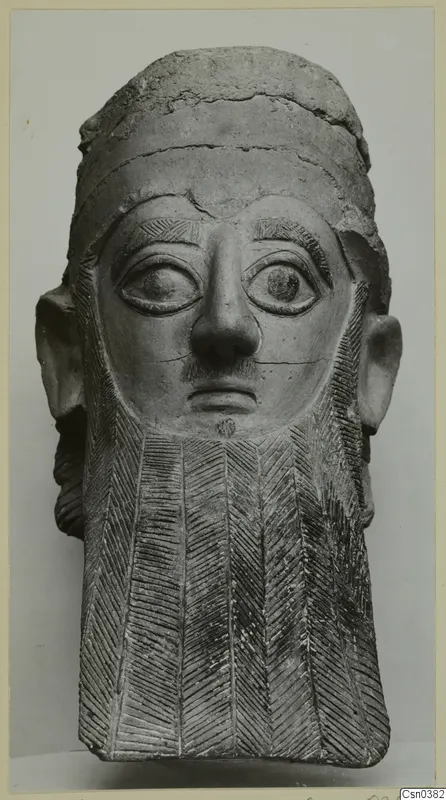 Terracotta head of a bearded figure with large eyes and a chevron-patterned beard