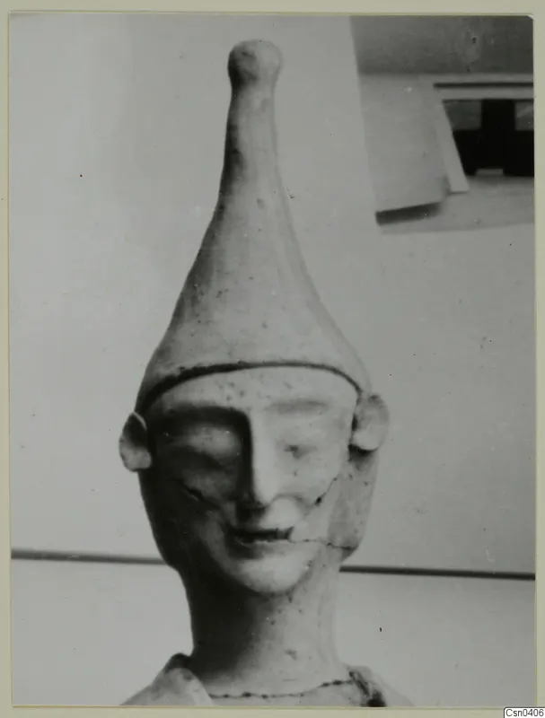 Terracotta figure head with a tall conical headdress and a smiling face, from Ayia Irini