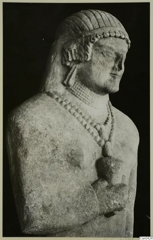 Limestone Cypro-Greek I statue, upper body, with banded hair, a beaded necklace and one hand held at the chest
