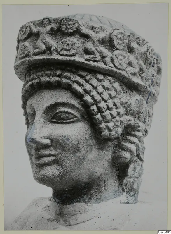 Limestone head from Arsos with a tall headdress decorated in relief and rows of curled hair