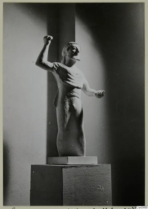 Limestone statue of a standing male figure with one arm raised, on a pedestal, from Kition
