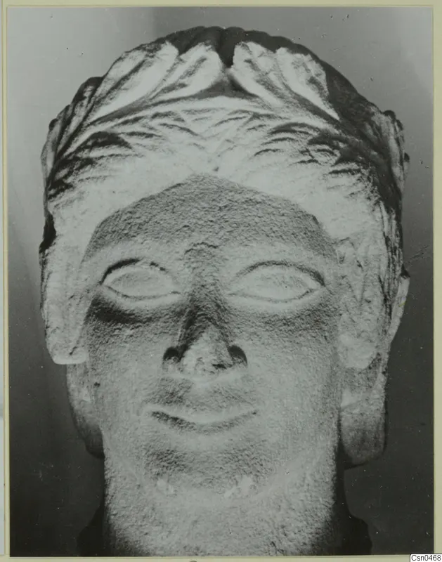 Frontal view of a limestone head from Mersinaki with carved hair and almond-shaped eyes