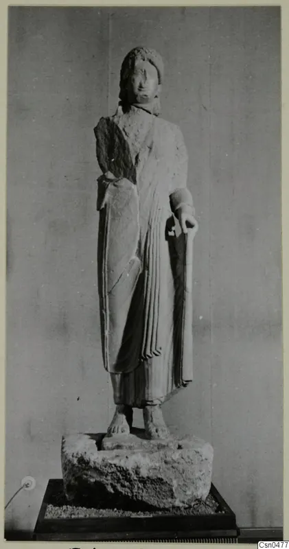 Limestone statue of a standing woman in a draped garment, set on a rough stone base