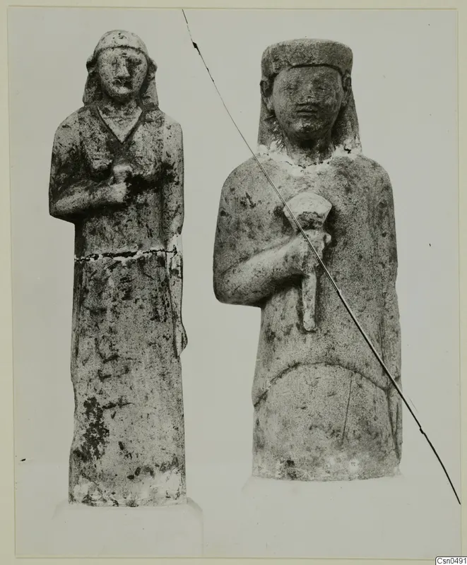 Two standing limestone statues of human figures, placed side by side.