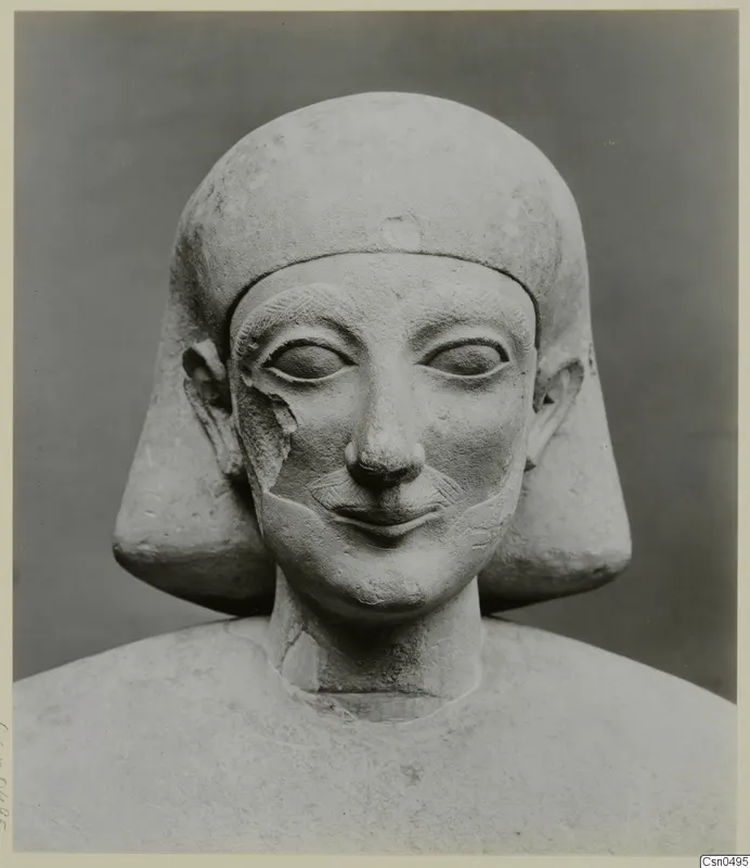 Limestone bust of a figure with a close-fitting headdress and a broad smile, Cypro-Egyptian, front view.