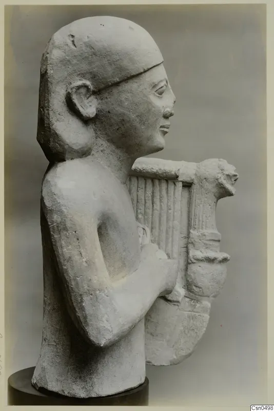 Limestone bust of a figure holding a lyre, shown in profile on a dark round base