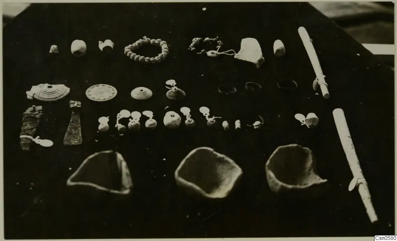 Bowls and jewellery from Cyprus, arranged in rows on a dark background