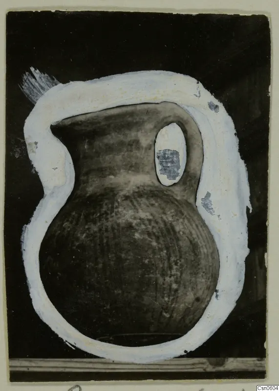 Dark jug with a single handle, outlined in white paint against a black background