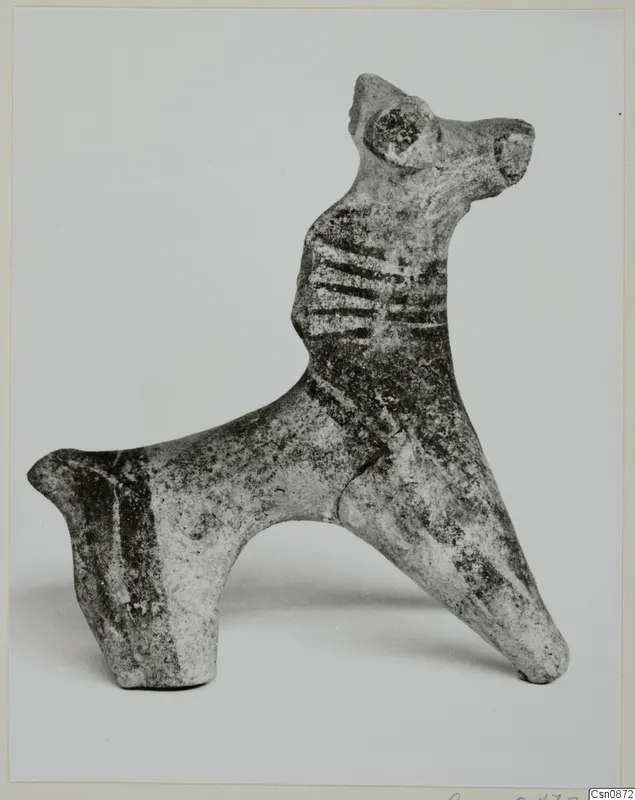 Small figurine of an animal with a long neck, pointed ears and dark painted bands across its body
