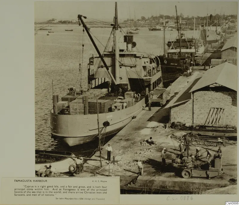 Famagusta harbour with a cargo ship being loaded by a crane, workers on the quay and a truck beside a warehouse