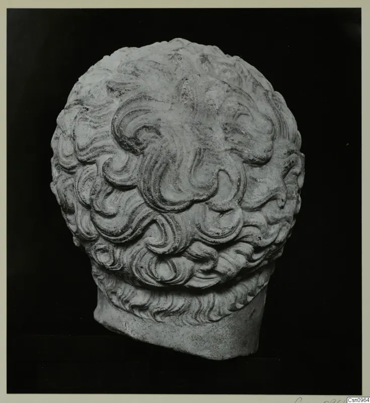Carved stone sculpture of a head with dense, curling locks and a flat-cut base.