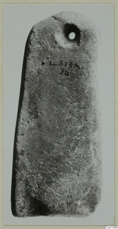 Flat perforated stone pendant with a handwritten label, photographed against a pale background