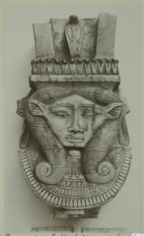 Carved female head with a tall headdress of cobras and spiral side locks, shown on a photo mount