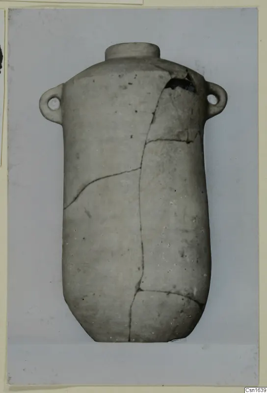 Cylindrical pottery vessel with a narrow neck and two small lug handles, cracked and mended, from Tomb 10 at Marion.