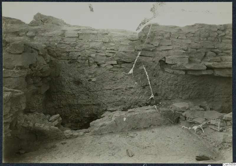 Excavated trench at Idalion acropolis with a stone wall face, mud-brick layers and stone blocks at its base
