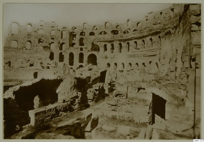 Ruined stone structure with tiers of arched openings and vaulted passages, North Africa