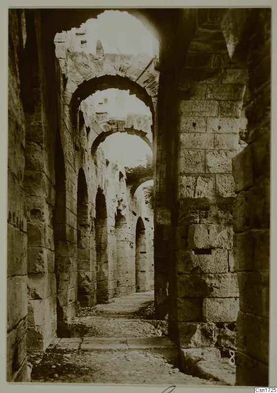 Stone passage with a row of arches receding into a ruined building, North Africa