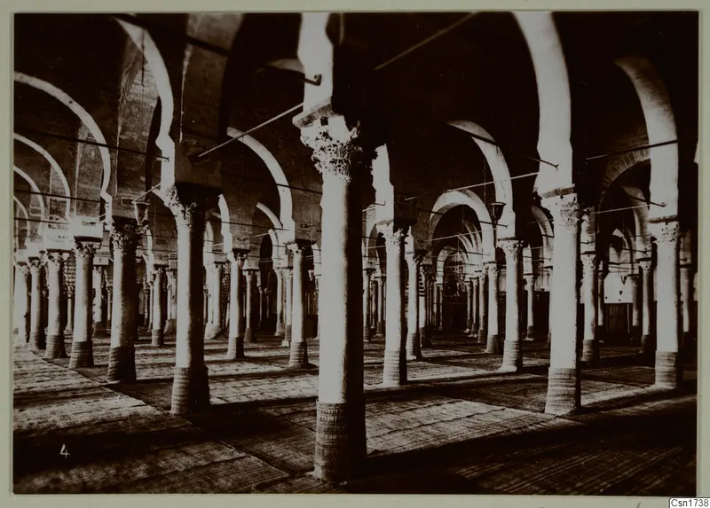 Interior of a building with long rows of stone columns and arches, North Africa.