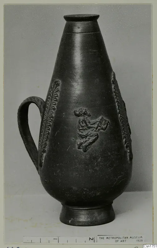 Dark pear-shaped jug with a loop handle and relief decoration of leaf-like bands and a small figure