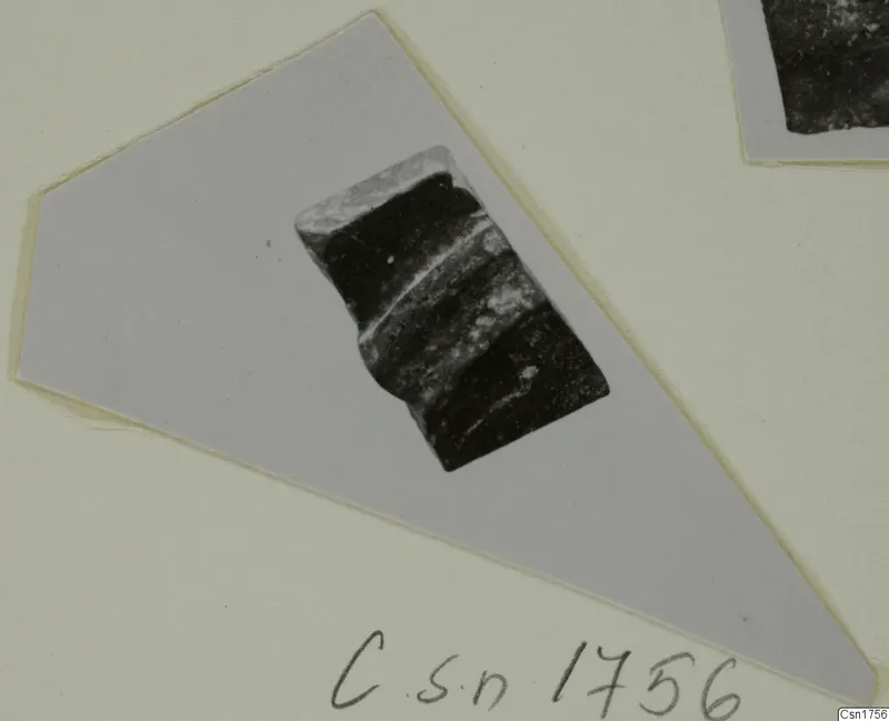 Dark pottery sherd with a ridged edge, shown on a pale grey mounted card, from the Roman Wares I-III group