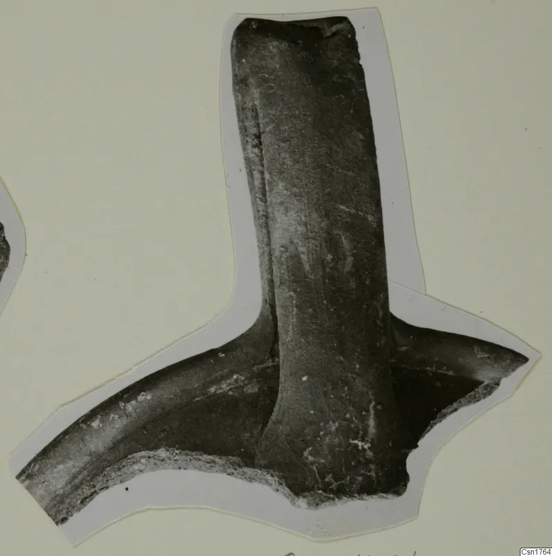 Pottery sherd with a thick vertical handle joining a curved body fragment, photographed on a cut-out card mount