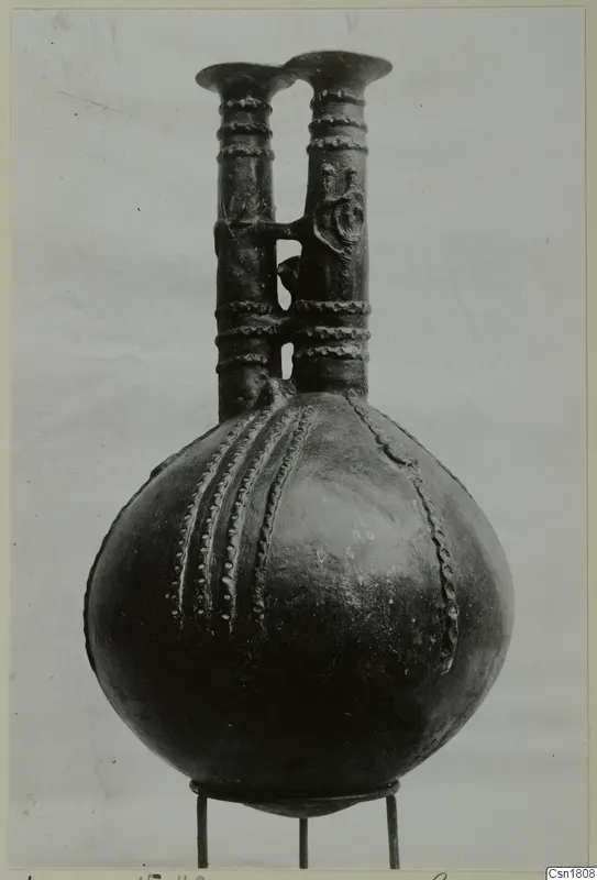 Red Polished III jug from Vounous with two tall necks and raised bead decoration, on a wire stand