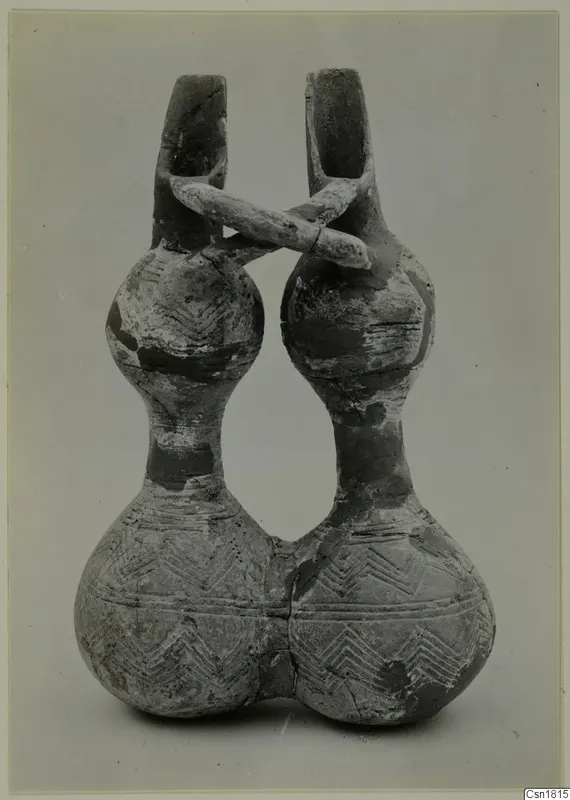 Pottery Red Polished III jug, double-spouted, with a bridge handle and incised chevron decoration