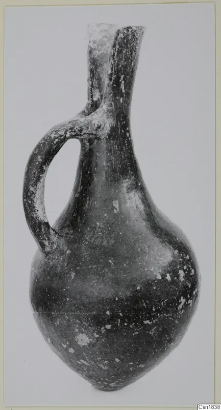 Red Polished I juglet from Vounous with a single loop handle and a pinched, two-lobed mouth.