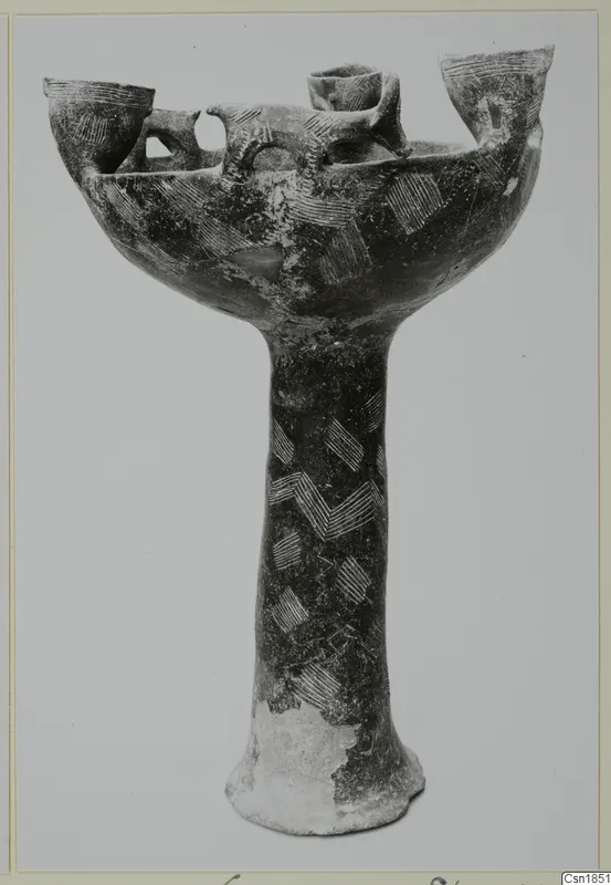 Pottery Red Polished I: a stemmed pottery vessel with a wide bowl, upright openings around the rim and incised hatched decoration