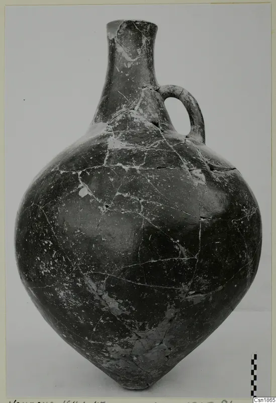 Red Polished I vessel with a tall neck and single loop handle, photographed against a plain background
